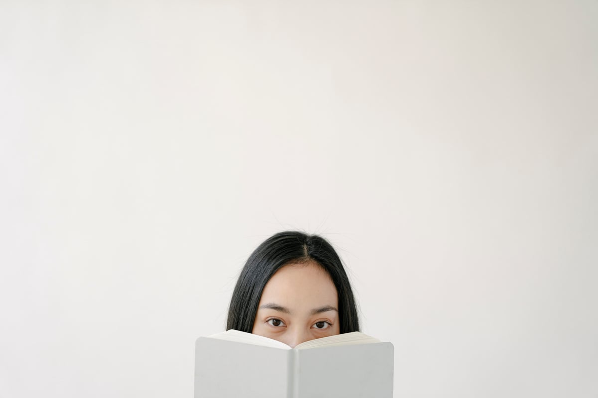 White wall with face of ethnic female and book