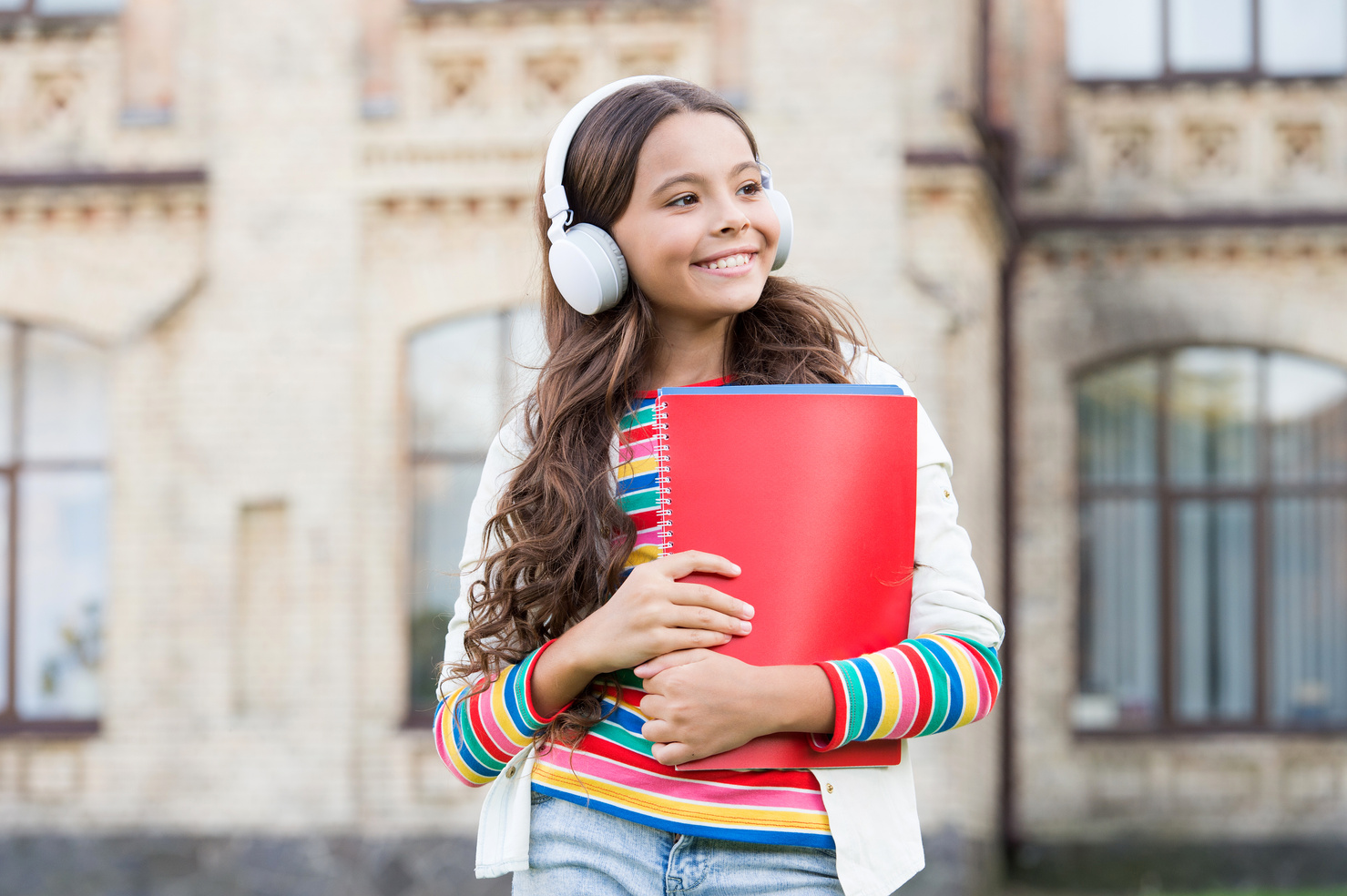 Do you speak english. Happy child listening to English audio course. Little girl learning English with audio book. Improve your English with audio lessons